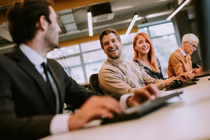 Professionals sitting next to each other engaging and laughing.