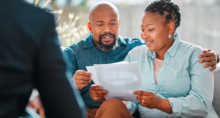  A couple on a couch reviews papers with an advisor