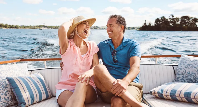 A couple on a boat looks at each other and smiles